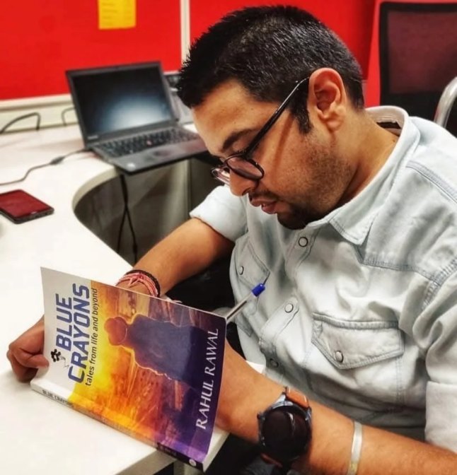 Rahul reading a copy of his book, Blue Crayons